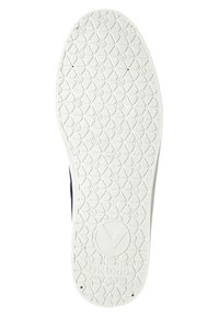 Bílá podrážka tenisky se šestiúhelníkovým vzorem a logem. Texturovaný povrch pro lepší přilnavost s odvodňovacími otvory. Boční kontury se mírně zvedají.