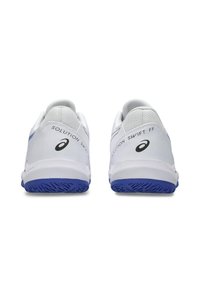 White athletic shoes featuring a mesh upper, blue accents, and a textured rubber sole with a distinct tread pattern. Logo printed on heel.