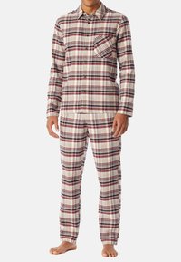 Pajama set w kratkę w kolorach czerwonym, białym i granatowym, wykonany z miękkiego materiału. Koszula z długim rękawem zapinana na guziki z kieszonką na piersi oraz pasujące spodnie.