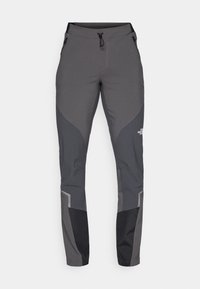 Szare spodnie trekkingowe o tapered fit, z wieloma kieszeniami oraz kontrastującymi ciemnoszarymi i czarnymi akcentami. Wykonane z elastycznego, wytrzymałego materiału.
