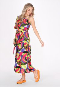 Abito maxi multicolore con design a spalla unica, vivaci motivi a foglia in rosa, verde e viola, e vita annodata.