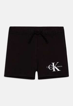 Sorte bomullsshorts med snor i livet og en hvit "CK" logo med teksten "Calvin Klein Jeans" nederst til venstre.