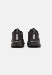 Black running shoes featuring a mesh upper, cushioned sole, and textured accents on the heel. Reflective logo and detailing.
