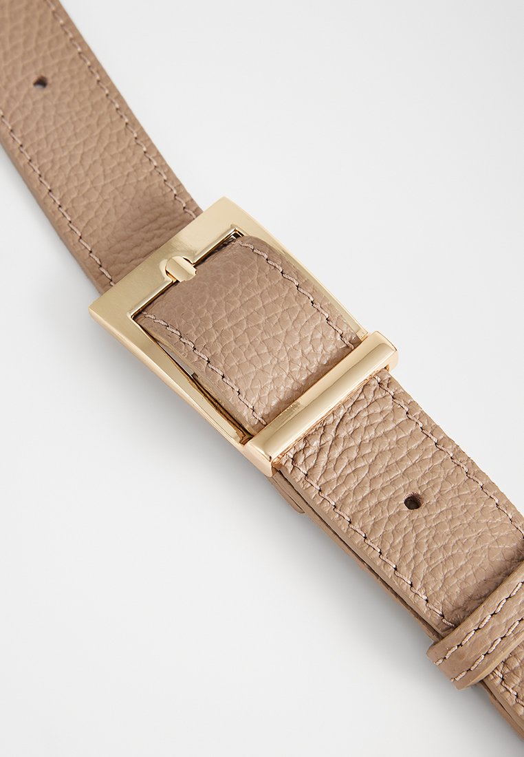 Ceinture en cuir texturé beige avec une boucle rectangulaire dorée et des détails de couture sur fond blanc.