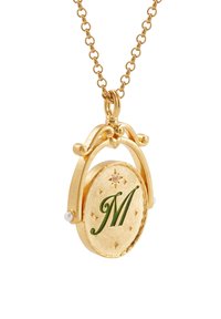 Ciondolo in oro a forma di medaglione con un'iscrizione "M" verde, stelle decorative e dettagli in perla, sospeso su una delicata catena in oro.
