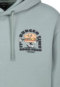 Mintgrüner Hoodie mit einem frontalen Grafikdesign eines lächelnden Burger-Charakters, auf dem der Text "ES IST BURGERZEIT" und "GUTES ESSEN" in fetter Schrift zu sehen ist.