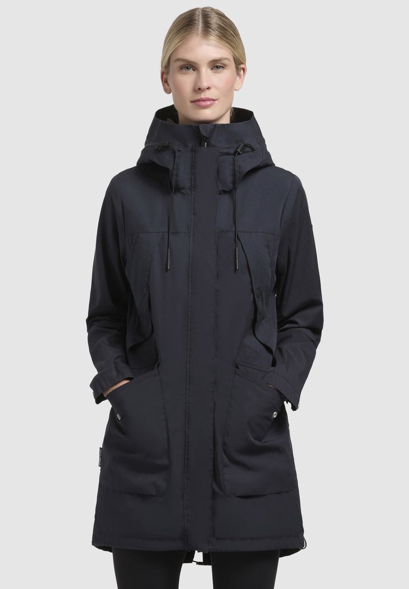 Navy parka jacket with a hood, front zip, two large side pockets, adjustable drawstrings, and a slightly longer back hem.