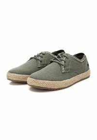 Zapatillas de lona verdes con suela de yute texturizada, diseño con cordones y detalles de costura en contraste. Punta redondeada y perfil bajo.