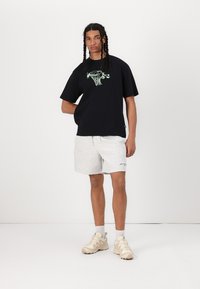 New Balance HOOPS TRADITION GRAPHIC UNISEX - Apdrukāts T-krekls - black