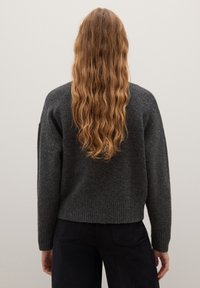 Dunkelgrauer Strickpullover mit lockerer Passform, geripptem Saum und überschnittenen Schultern, aus einem weichen, strukturierten Material gefertigt.