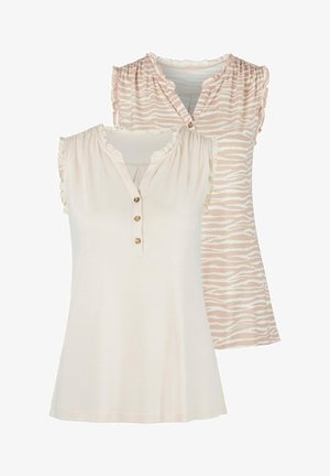 Deux hauts pour femmes : l'un en crème uni avec des manches volantées et trois boutons, l'autre en rose clair avec un motif zèbre.