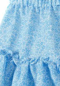 Fustă florală albastră, realizată dintr-un material moale, cu un tiv volanat. Are un fundal bleu deschis și modele de flori albe mici pe întreaga suprafață.