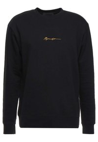 Zwarte sweatshirt met lange mouwen, ronde hals en een gouden geborduurd detail in sierletters aan de voorkant. Zacht katoenen materiaal, eenvoudig ontwerp.