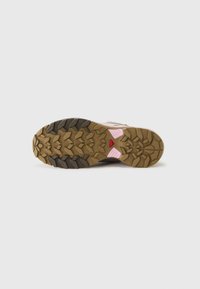 Trail schoen zool met een gestructureerde rubberen zool en een geometrisch loopvlakpatroon in bruin en zwart, accentueert met roze en een rood logo.