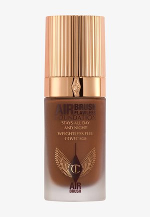 Foundation bottle with a gold ridged cap, amber liquid inside, and elegant branding in gold and burgundy. Text reads "Weightless Full Coverage."