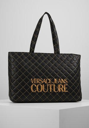 Sort quiltet tote taske med gyldne syninger og gyldent "Versace Jeans Couture" logo, med to polstrede skulderstropper.