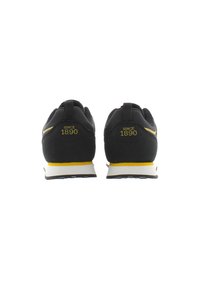 Sneakers neri con una striscia di accento gialla con la scritta "SINCE 1890", tomaia in tessuto testurizzato e suola bianca con motivo antiscivolo.