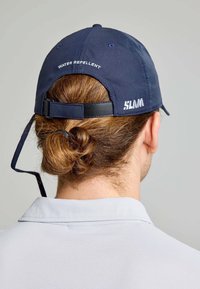 Cappellino da baseball impermeabile navy con visiera piatta, logo "SLAM" ricamato e cinturino regolabile sul retro. Tessuto testurizzato.
