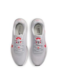 Scarpe da ginnastica bianche con upper testurizzato, dettagli rosa sulla swoosh e sul tallone, e un sistema di lacci rotondo. Presenta un collo imbottito.