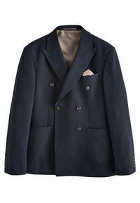 Dvouřadý navy blazer s texturovanou tkaninou, dvěma předními kapsami a krémovou kapesníčkou. Manžety na knoflíky a vzorované vnitřní podšívky.