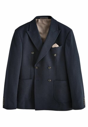 Dunkelblauer, doppelt geknöpfter Blazer aus strukturiertem Stoff, mit zwei Vorderaschen und einem cremefarbenen Einstecktuch. Geknöpfte Manschetten und ein gemustertes Innenfutter.