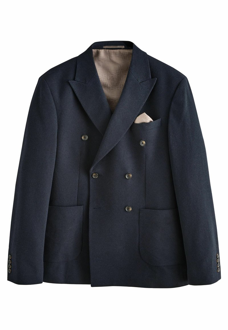 Dvouřadý navy blazer s texturovanou tkaninou, dvěma předními kapsami a krémovou kapesníčkou. Manžety na knoflíky a vzorované vnitřní podšívky.