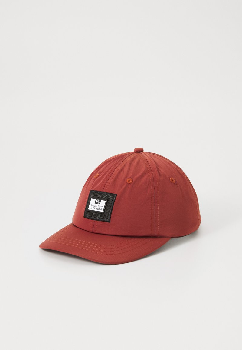 Rød caps laget av lett stoff, med en svart lapp med tekst, buet skygge og sydd detaljer langs kantene.