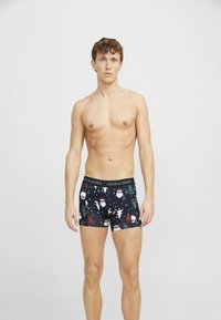 Muške bokserice od tamnog materijala s blagdanskim uzorkom Djeda Božićnjaka i drvca. Elastična traka u struku s "JACK & JONES" logotipom. Dužina do sredine bedra.