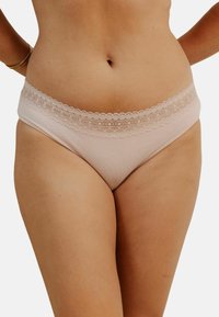 Culotte en coton rose clair avec une taille en dentelle. Le design présente une texture lisse et une coupe offrant une couverture moyenne.