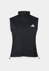 Svart ermeløs vest med høy krage. Har glidelås foran, lett stoff og en hvit logo med tre striper på øvre venstre side.