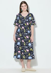 Sukienka w granatowym kolorze z kwiatowym wzorem, krótkimi rękawami, dekoltem w serek i detalami z guzikami. Charakteryzuje się kolorowymi kwiatami i liśćmi na tle falistego wzoru.