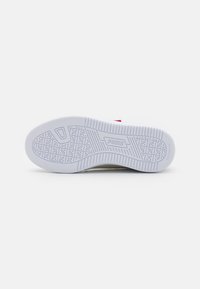 Weißer Sport Schuhsohle mit strukturiertem, gemustertem Griff. Enthält die "PUMA"-Markierung und eine leicht erhöhte Kante um den Umfang.