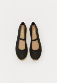 Ballerine nere con tomaia in tessuto morbido, punta rotonda, dettaglio a fiocco e soletta beige. Bordo in juta naturale lungo la suola.