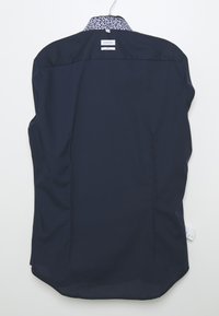 Donkerblauwe blouse met kraag van gladde stof, met een gemusterde binnenkraag, recht gesneden en met zijsplitten aan de onderrand.