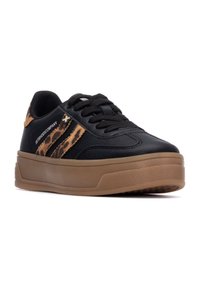 Zapatilla negra con cuero texturizado y acentos de estampado de leopardo, que cuenta con un diseño de cordones y una gruesa suela de goma marrón.