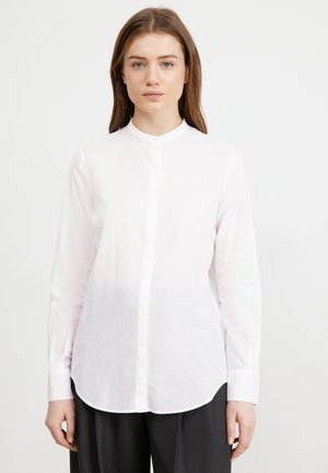 White long-sleeve button-up shirt with a collar, made of lightweight fabric, featuring a straight cut and a curved hem.