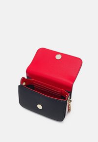 Piccola borsa con un interno in pelle rossa texture e un esterno blu navy. Presenta una chiusura a scatto dorata e diverse fessure per carte.