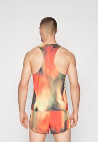 Ärmelloses Herrenoberteil mit einem Farbverlaufsmuster in Schattierungen von Rot, Orange und Schwarz. Der Stoff hat ein strukturiertes, atmungsaktives Design.
