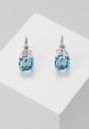 Zilveren oorbellen met grote vierkante blauwe edelstenen en drie kleine heldere ronde en driehoekige stenen boven elke edelsteen.