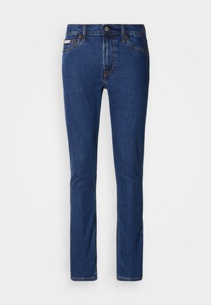 Mørkeblå jeans lavet af denim, med slim fit, normal taljehøjde, fem-lomme design og kontrasterende syninger.
