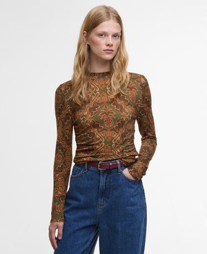 Langemouwtop met een groene basis en een ingewikkeld oranje bloemenpatroon, gecombineerd met hoge taille spijkerbroek in het blauw en een bordeauxrode riem.