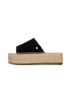 Sandalias de cuña de ante negro con suela de cuerda de yute. El diseño presenta una parte superior ancha y un adorno decorativo plateado en el lateral.