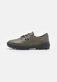 Sapatilha verde-oliva com material suave, design de atacador preto, biqueira reforçada e sola robusta para tração. Logótipo da marca na lateral.
