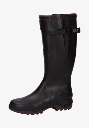 Bota de lluvia de goma marrón con un caño alto, superficie texturizada y suela resistente. Cuenta con una correa y hebilla para ajuste.