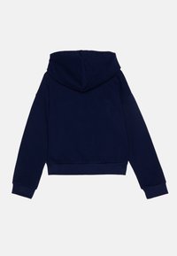 Felpa cropped blu navy con cappuccio regolabile, maniche lunghe e polsini a coste. Tessuto morbido con una superficie liscia, dettagli minimi.