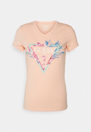 Ferskenfarvet v-hals t-shirt lavet af bomuld, med en blomstertrifor grafisk design og teksten "GUESS U.S.A." i hvid og grønne accenter.
