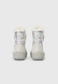 Botas metálicas plateadas con forro blanco esponjoso, correas ajustables y una suela de goma texturizada. Presenta acentos iridiscentes para un detalle adicional.