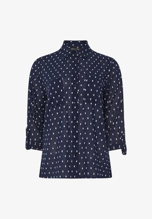 Granatowa koszula zapinana na guziki z białymi prostokątnymi wzorami, z długimi rękawami podwiniętymi przy mankietach oraz dwiema kieszeniami na piersi. Wykonana z lekkiego materiału.