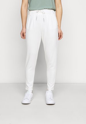 Vita tapered sweatpants med elastiskt midjeband och snörning, med sidofickor och slät tyg, i kombination med vita sneakers.