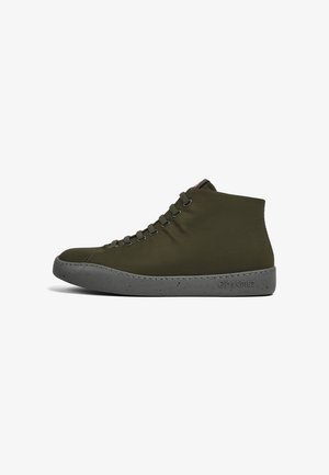 High-top sneaker in olive green fabric with a gray speckled rubber sole. Features six metal eyelets with matching laces and a brand logo.